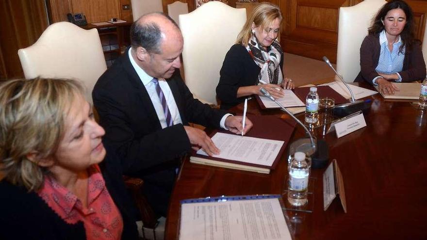 Carmela Silva y Salustiano Mato durante la firma del convenio en presencia de las investigadoras María Calviño y Josefina Garrido. // R. V.