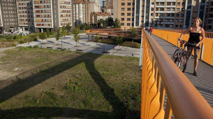 Una ciclista, en la pasarela peatonal que une Moreda y el Polígono.