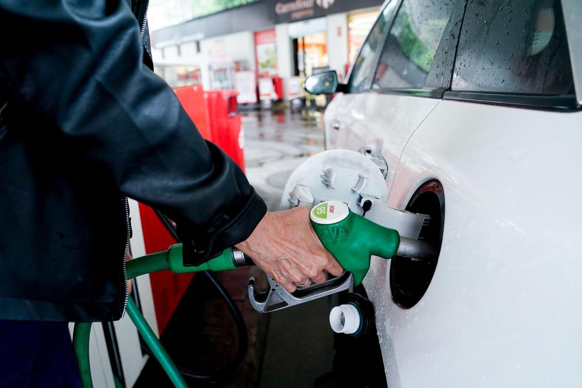 Una mujer reposta en una gasolinera.