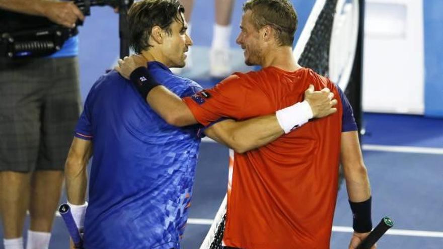 Ferrer recibe las felicitaciones del australiano Lleyton Hewitt tras ganar su partido.