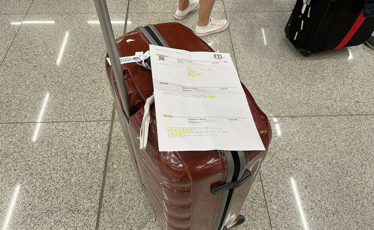 Eine Urlauberin hat ihre FTI-Buchungsbescheinigung am Flughafen Palma auf den Koffer gelegt. | FOTO: DM