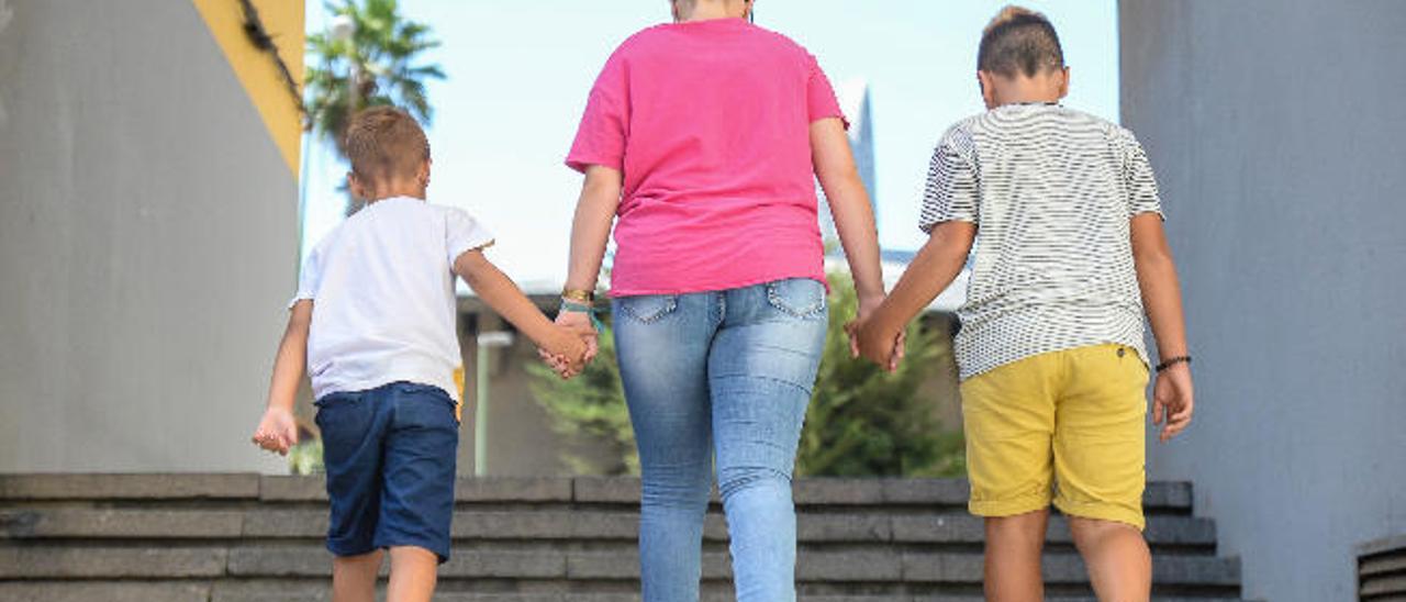 Tres menores pasean cogidos de la mano en la capital grancanaria.