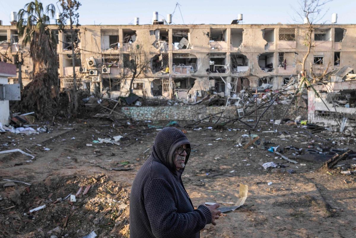 Hombre observa los daños de un ataque con misiles iraníes en Dimona