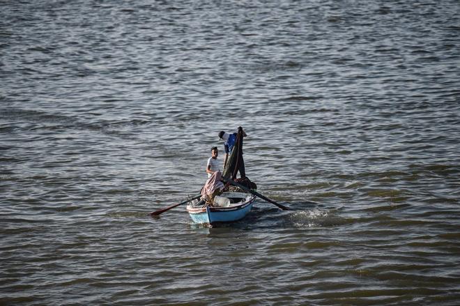 El pescador arroja su red de pesca en el canal de Suez, cerca de la ciudad de Ismailia, durante la Copa de África de África 2019 (CAN) en Egipto.
