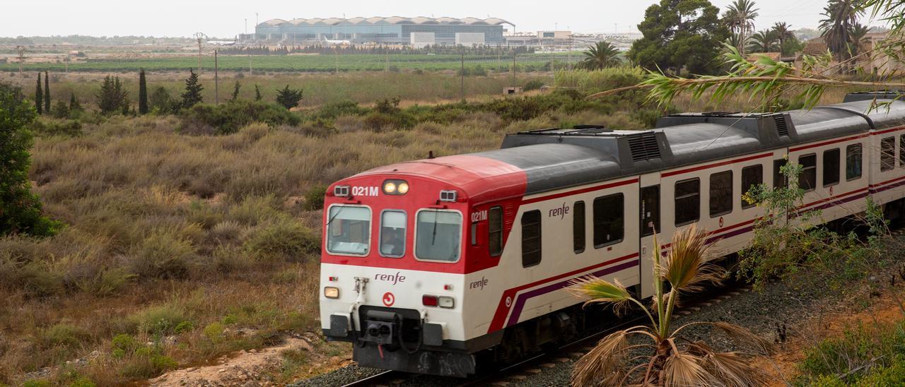 Imagen de un tren cercanías. Al fondo el aeropuerto de Alicante-Elche