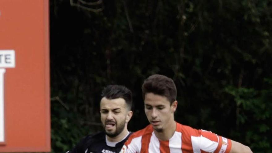 Jaime Santos lleva el balón presionado por Emilio, del Siero.