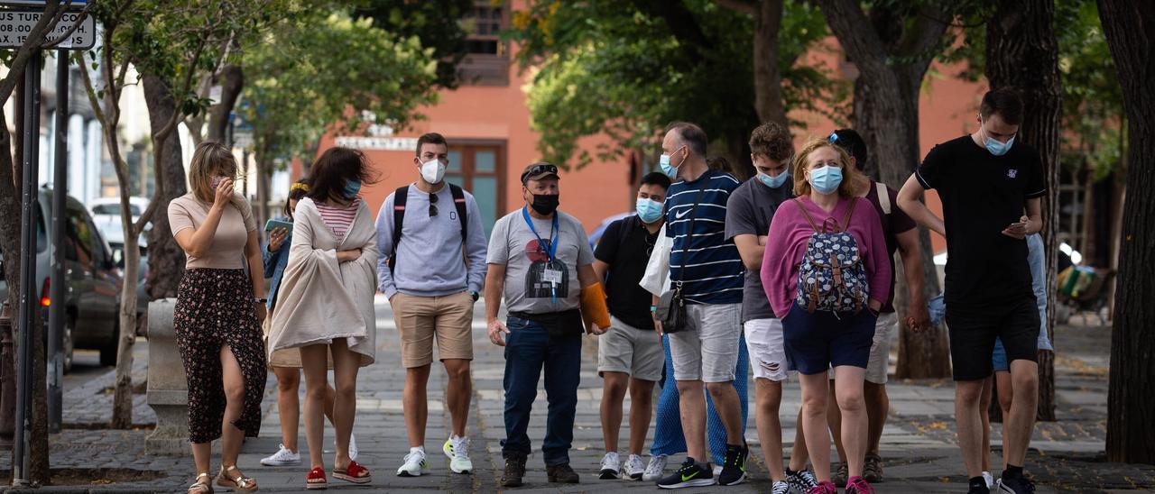 Un grupo de personas pasea por Santa Cruz de Tenerife portando sus mascarillas.