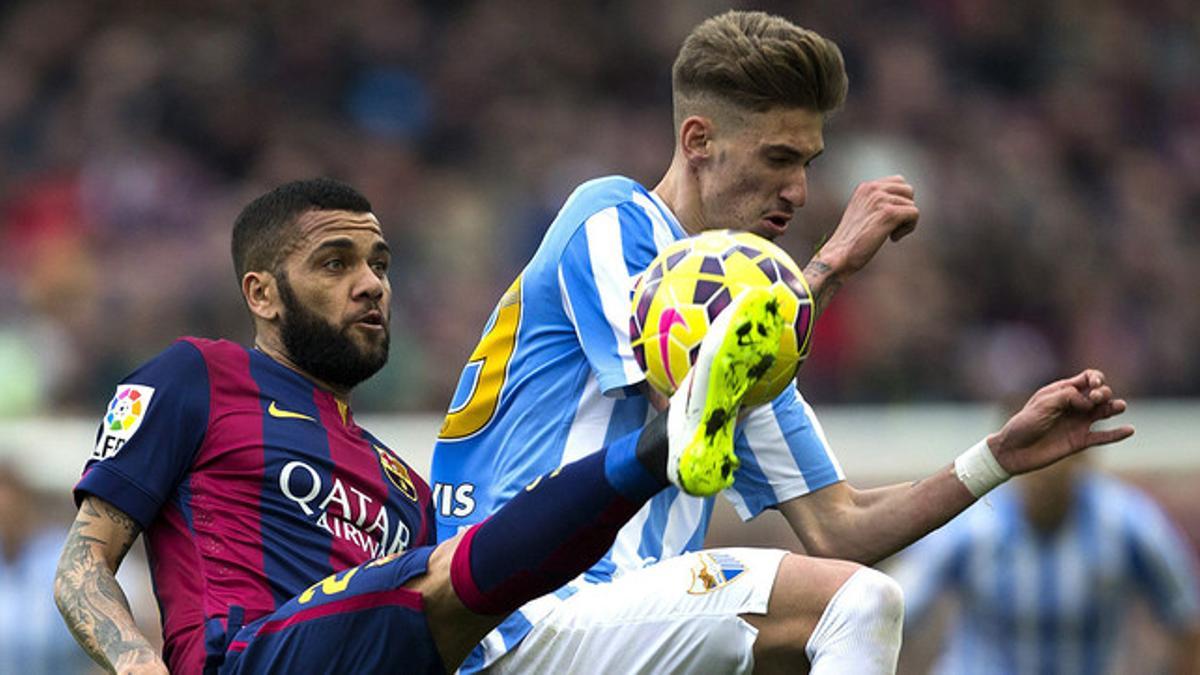 Dani Alves pelea un balón con Samu Castillejo, en el choque entre Barça y Málaga en el Camp Nou