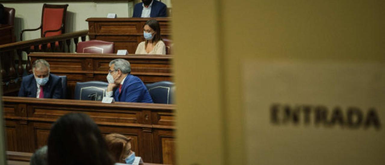 El presidente Ángel Víctor Torres, al fondo, escucha al vicepresidente Román Rodríguez durante el Pleno del Parlamento de ayer