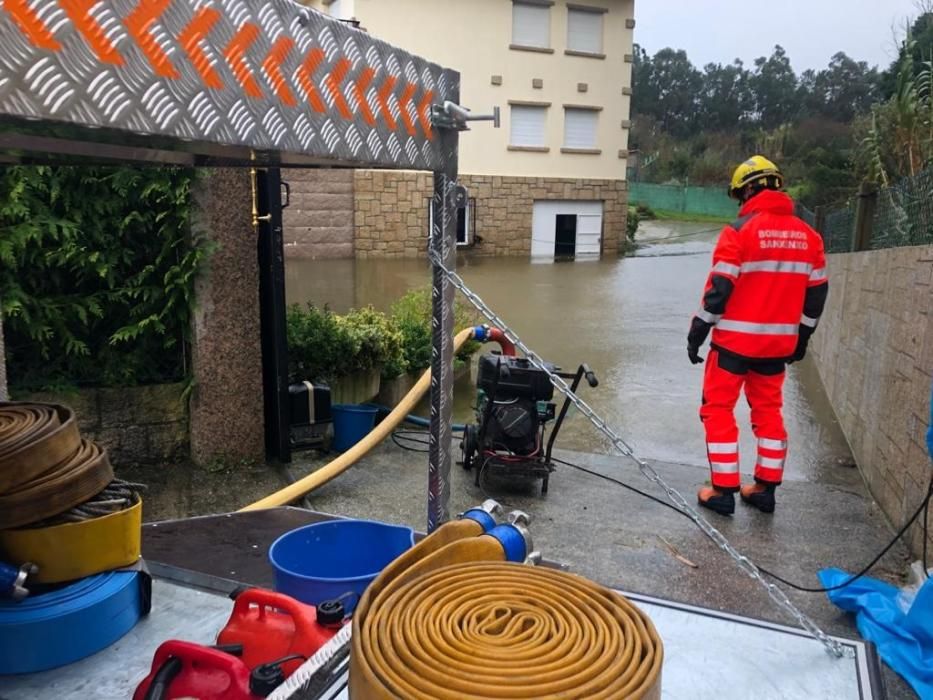 Bomberos achicando agua en un sótano de Canelas, Sanxenxo.