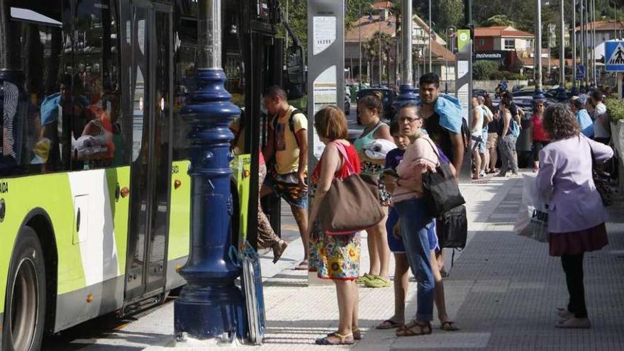 Usuarios de Vitrasa subiéndose al autobús en las paradas habilitadas frente a la playa. // R. Grobas