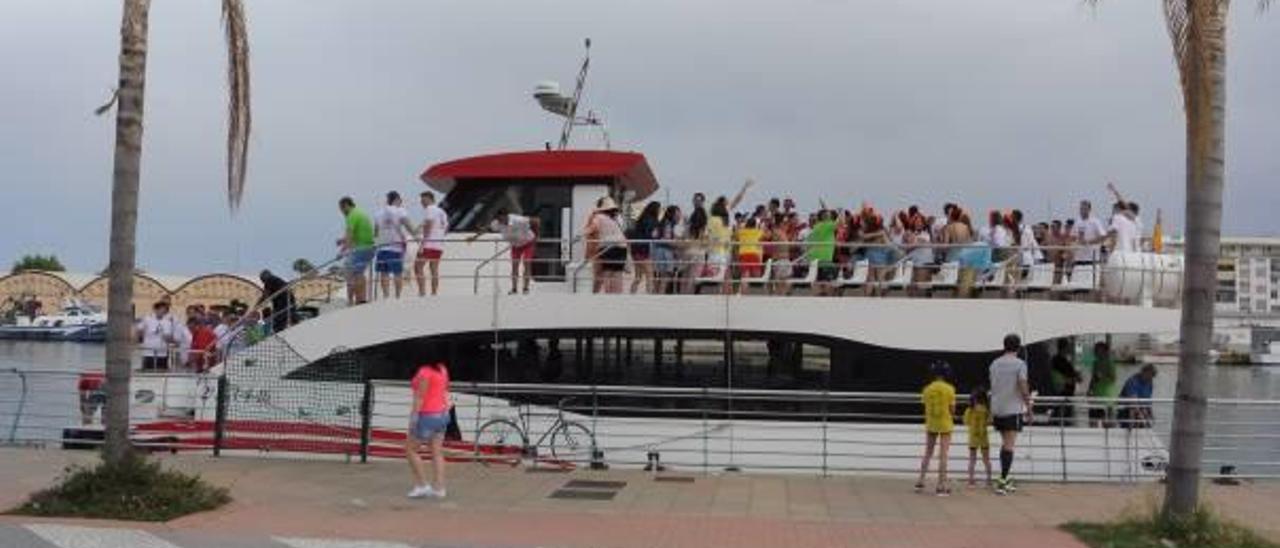 Un barco lleno de jóvenes celebrando despedidas en el Moll dels Borja de Gandia.