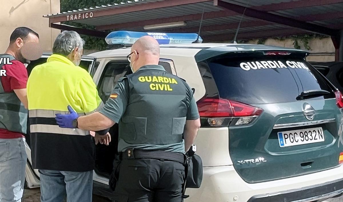 Agentes de la Guardia Civil meten en el coche al presunto autor de matar a tiros a un vecino en Archena.
