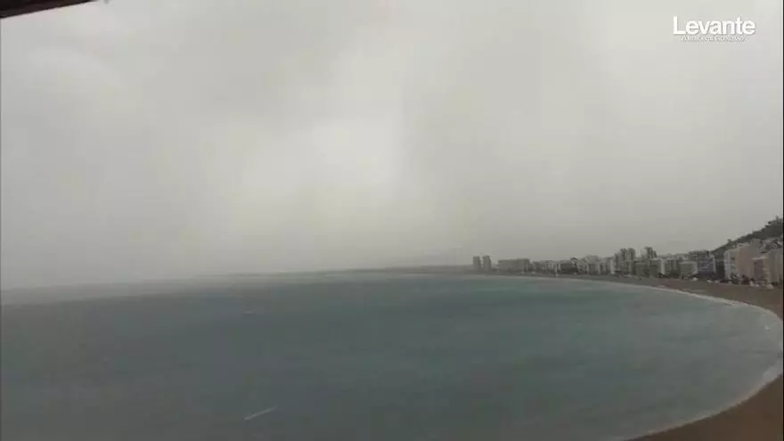 La sorprendente salida de una tormenta al mar en Cullera: una cortina lluvia infinita con rayos