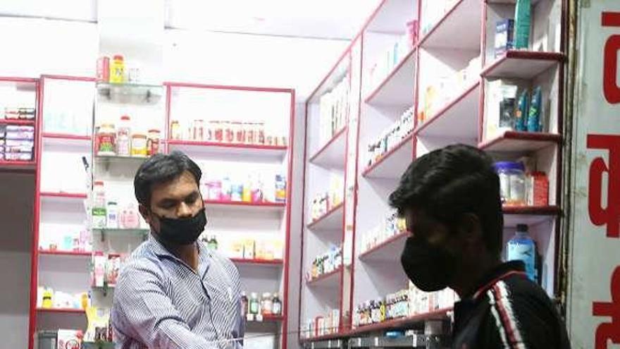 Un cliente muestra una receta en una farmacia de Bhopal. // Efe