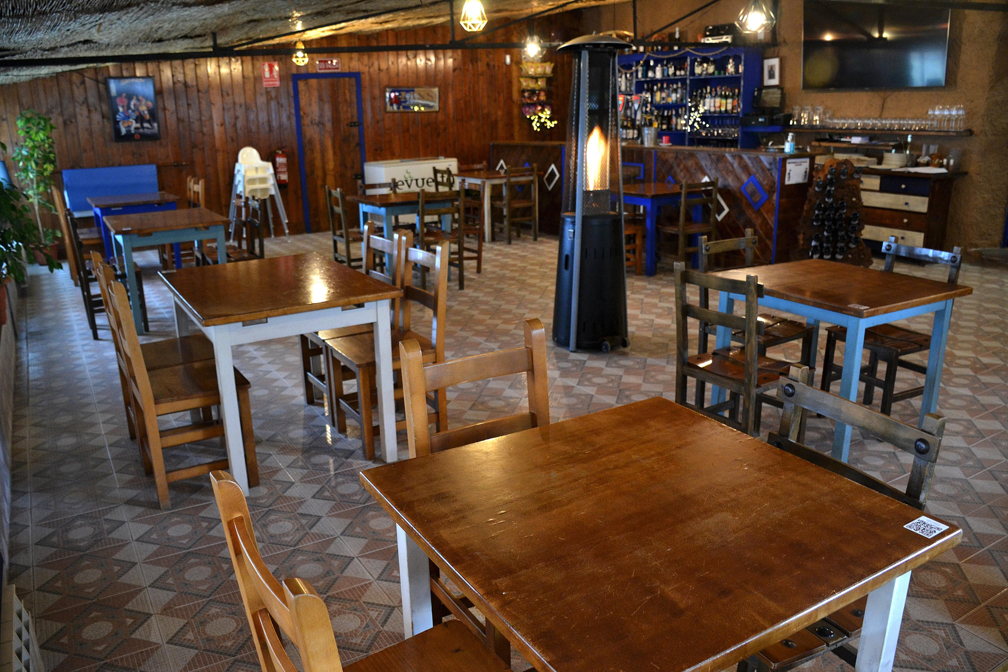 Comedor de madera, separado de la zona del chigre,  decorado con calidez.