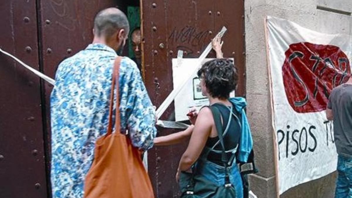 La escenificación 8 Los vecinos precintan de forma simbólica una finca turística ilegal en el Raval.