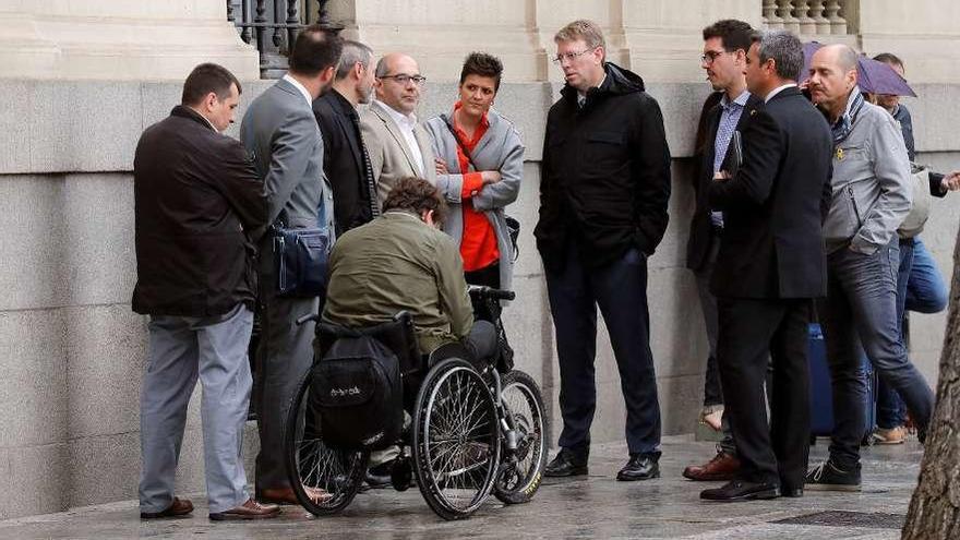 Lluis Guinó, antiguo miembro de la Mesa del Parlament, en el centro de la foto, rodeado de compañeros del PDeCAT, ayer a la puerta del Tribunal Supremo. // Efe