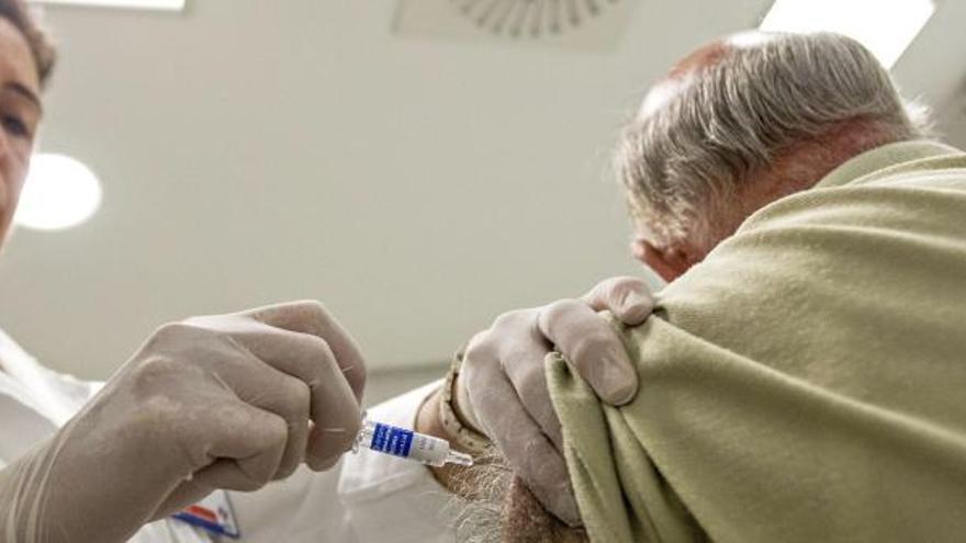 Una enfermera vacuna a un paciente contra la gripe en Valencia.