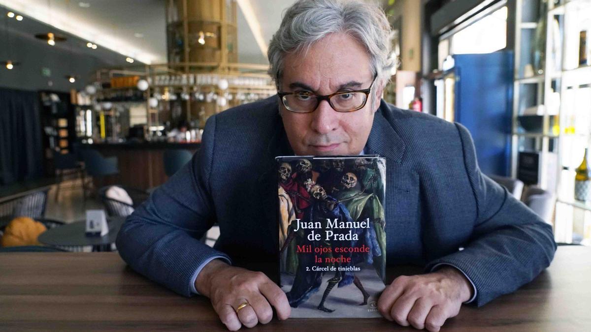 El escritor, Juan Manuel Prada, posa con su última novela, "Mil ojos esconde la noche"