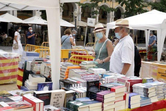 Una parella mirant llibres al Sant Jordi d'estiu a Girona.