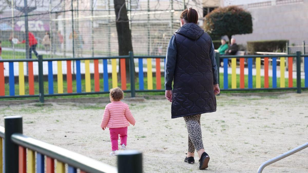 Una madre junto a su hija en un parque de la ciudad.