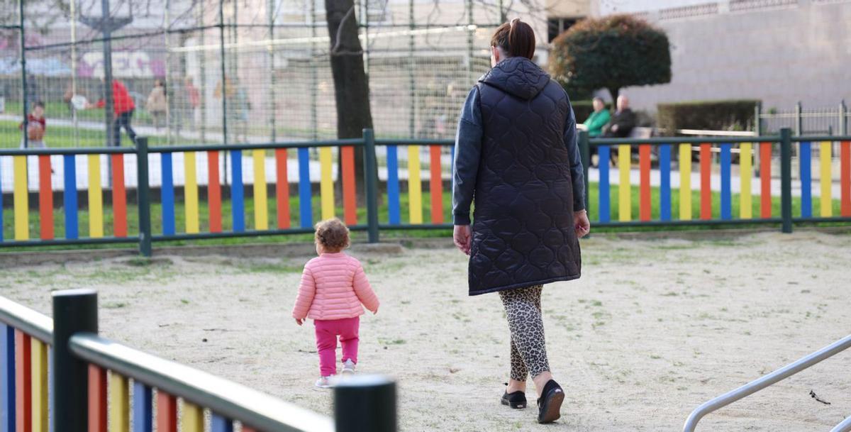 Una madre junto a su hija en un parque de la ciudad.