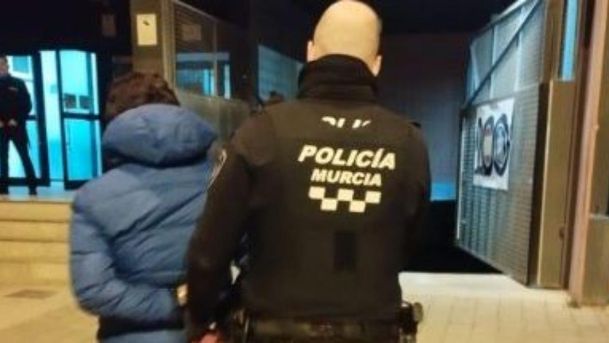 Un agente de la Policía Local de Murcia traslada al sospechoso a la Comisaría de Distrito del Carmen.