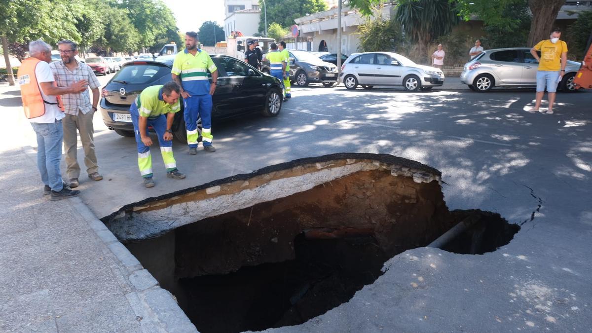 Imagen del gran socavón con el coche fuera de peligro.