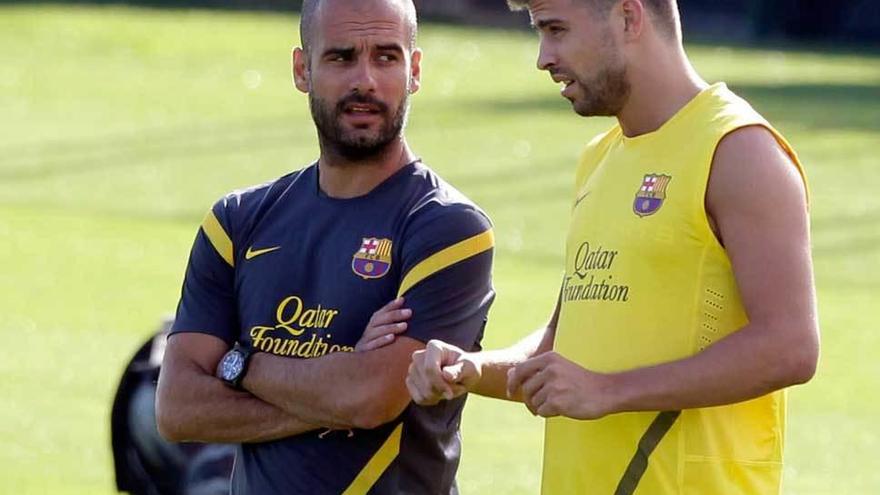 Guardiola charla con Piqué, en un entrenamiento del Barcelona en 2011.