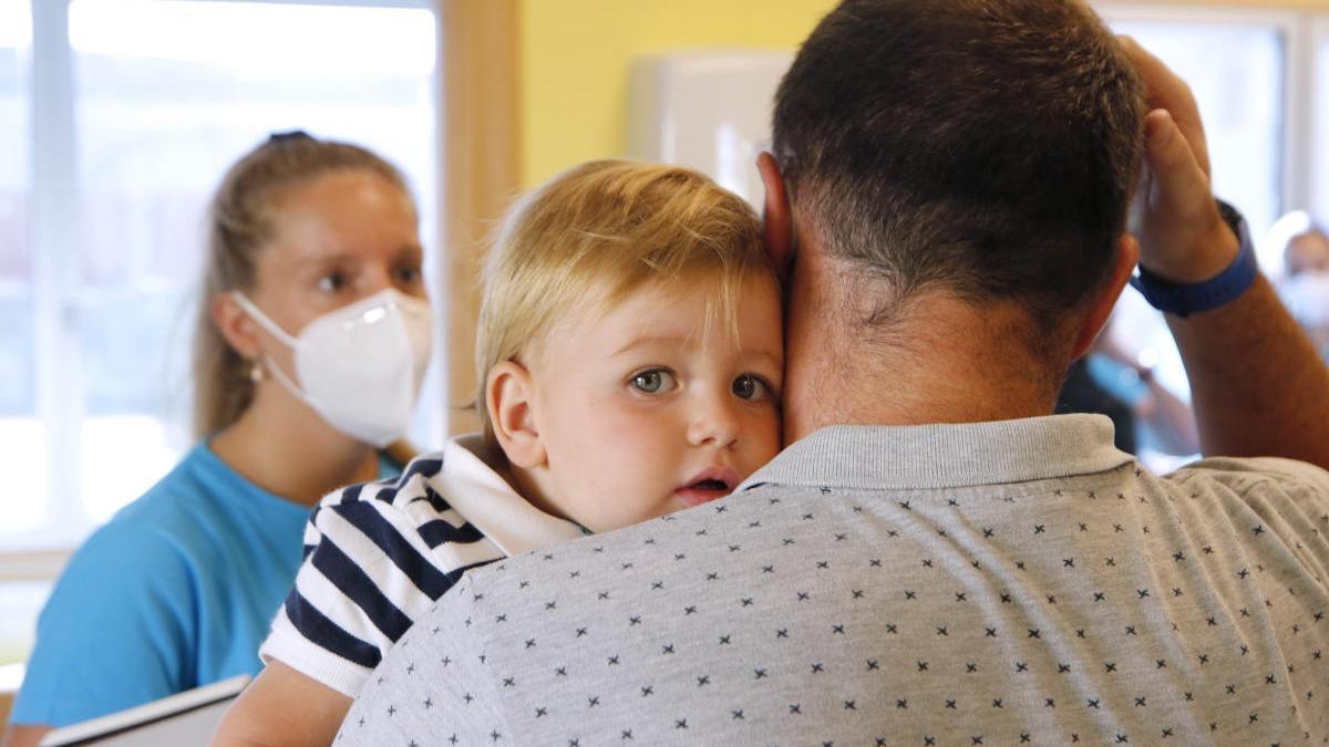 Un padre lleva a su hijo a la escuela infantil tras su reapertura. // Alba Villar