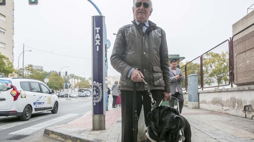José Vicente Toledo, junto a su perro guía, en una parada de taxis de la ciudad de Alicante.