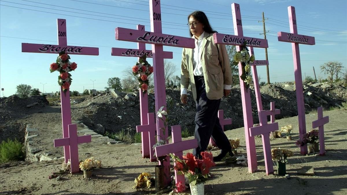 Una mujer pasea entre cruces de homenaje a mujeres asesinadas en Ciudad Juárez.