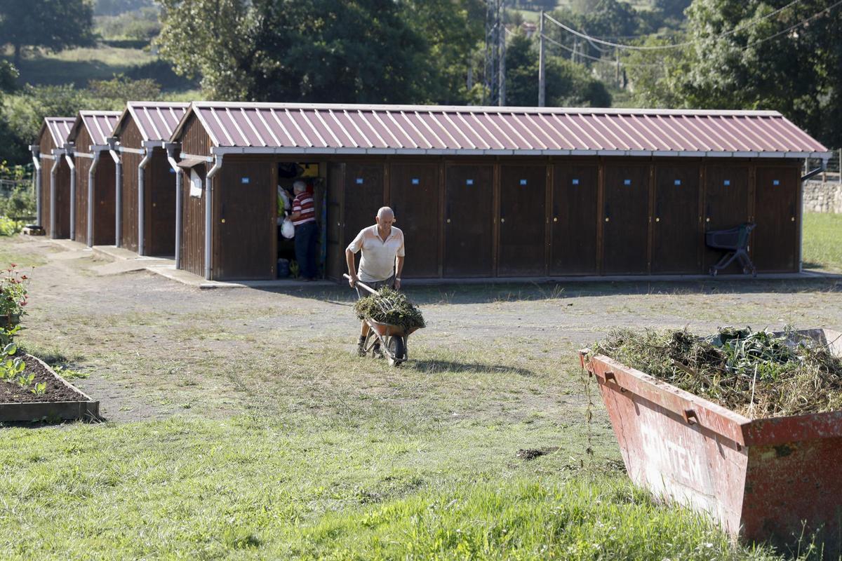 Un usuario de los huertos de Leorio con las casetas al fondo.