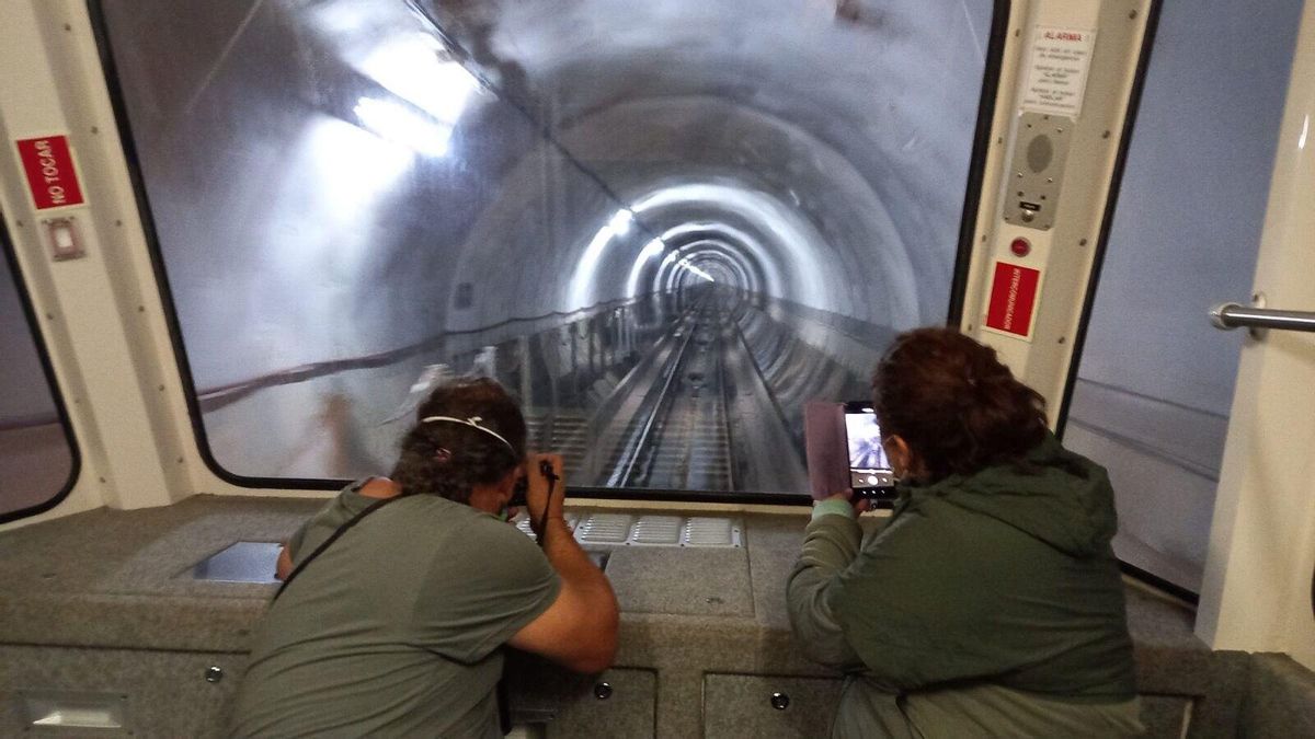 Dos turistas fotografían el túnel en el descenso hacia Poncebos.