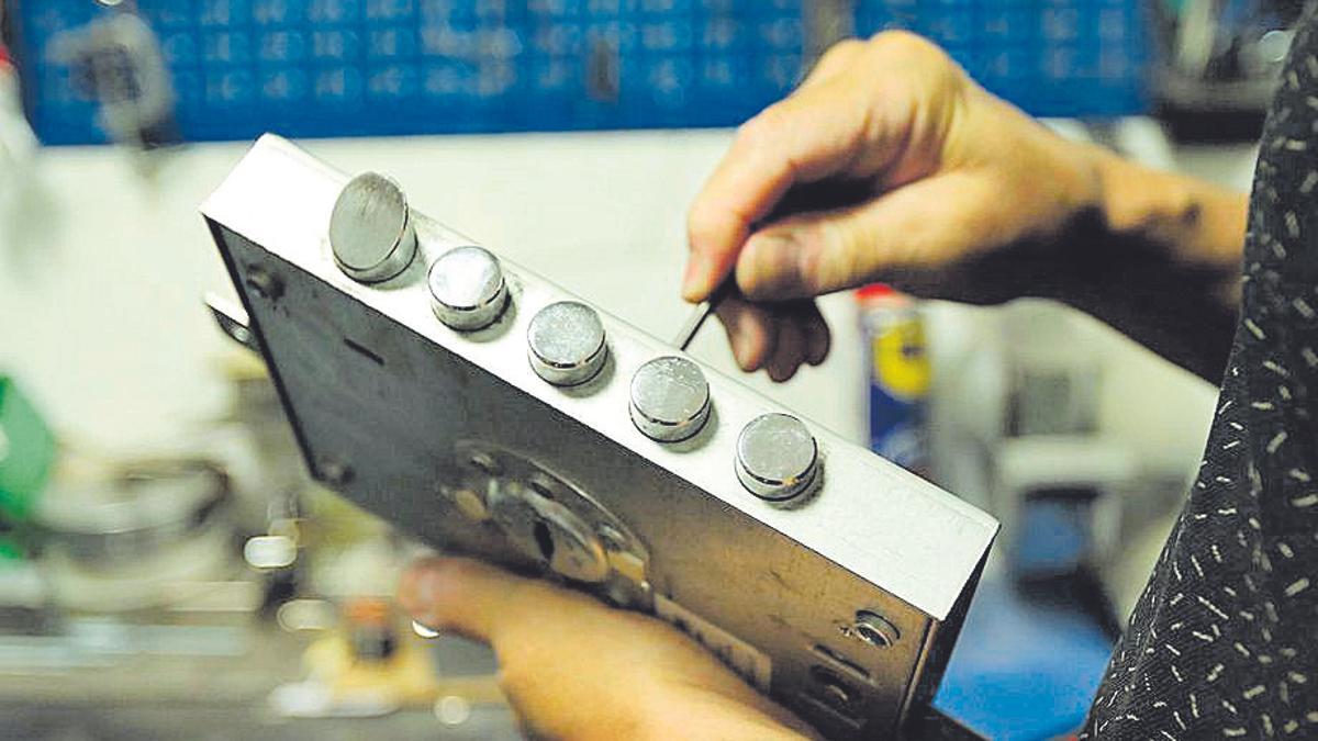 Un cerrajero trabaja con un bombín.