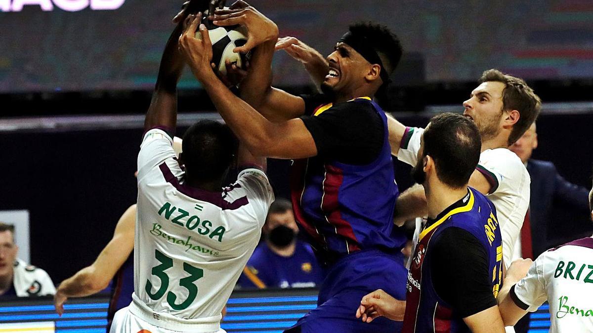 El pívot estadounidense del Barça Brandon Davies lucha con Yannick Nzosa (i), de Unicaja. EFE/Juan Carlos Hidalgo