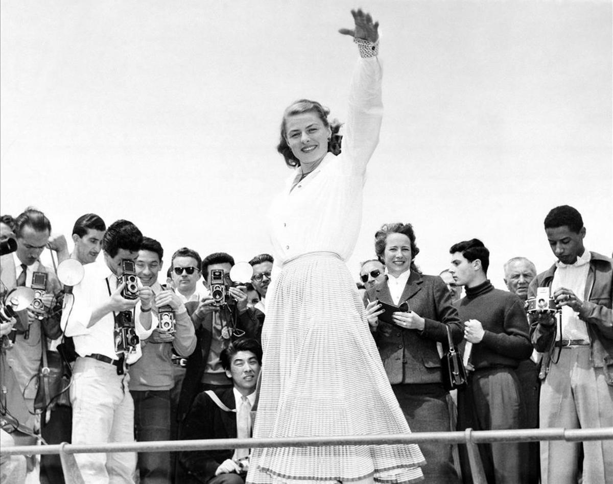 16 de mayo de 1956.  Ingrid Bergman, rodeada de fotógrafos a su llegada al festival de cine. 