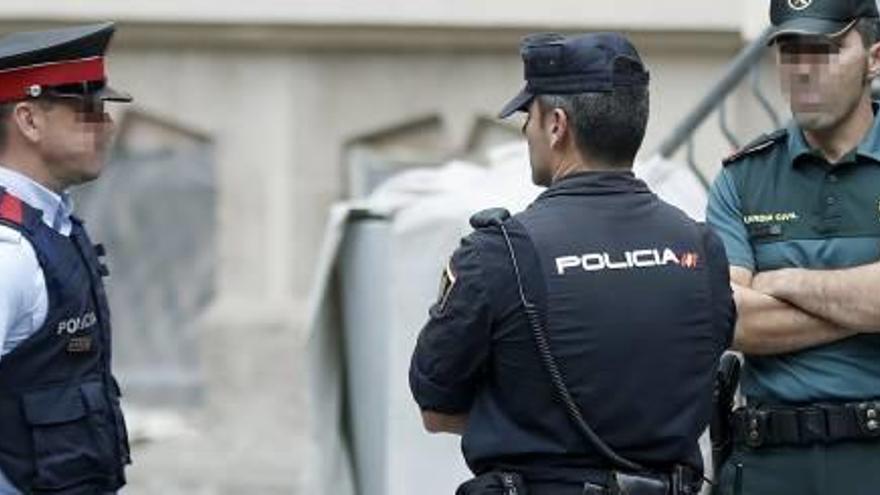 Un agent dels Mossos, un de la Guàrdia Civil i un de la Policia Nacional, dilluns a Barcelona.