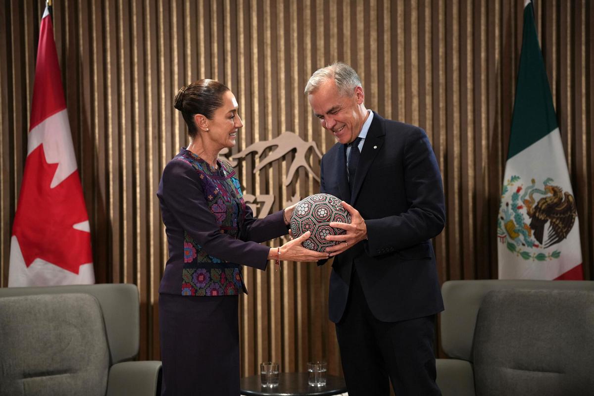 La presidenta de México, Claudia Sheinbaum, regalando un balón de fútbol al primer ministro canadiense, Mark Carney (d).