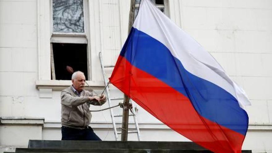 Un home treu la bandera de l&#039;ambaixada russa a Londres el passat 14 de març.