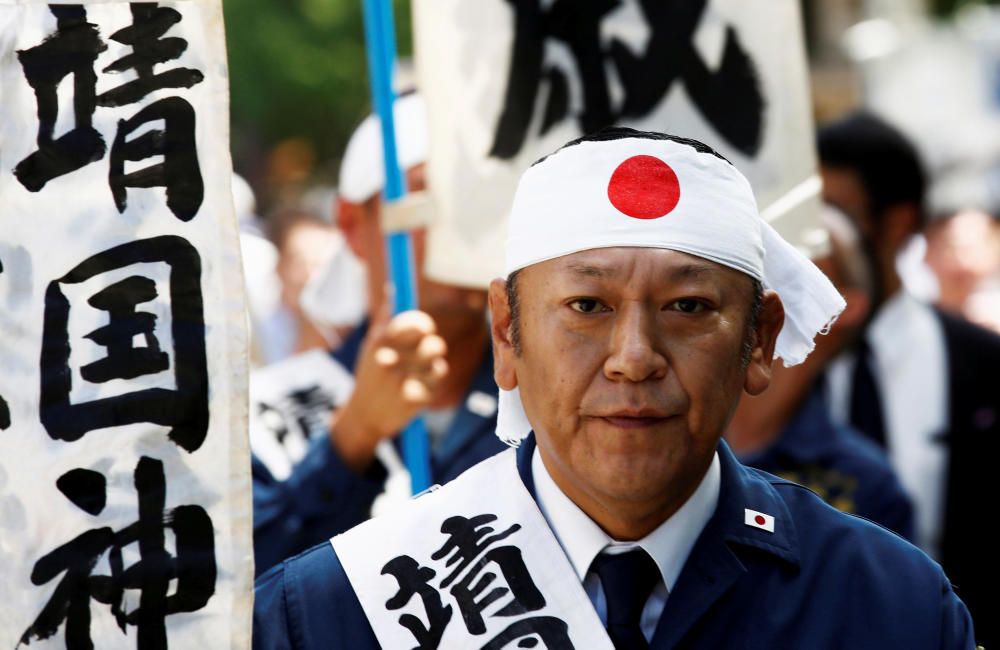 Un hombre lleva una diadema con la bandera de Japón mientras visita el santuario Yasukuni.