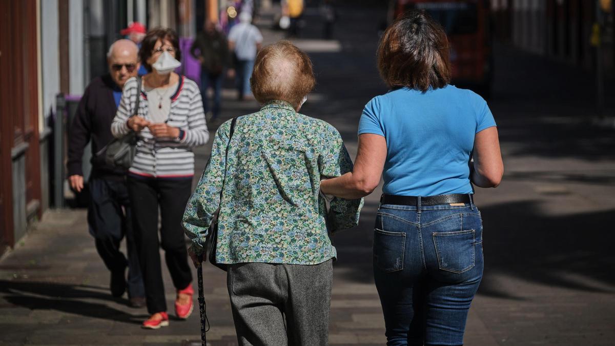 Una persona mayor camina acompañada en La Laguna.