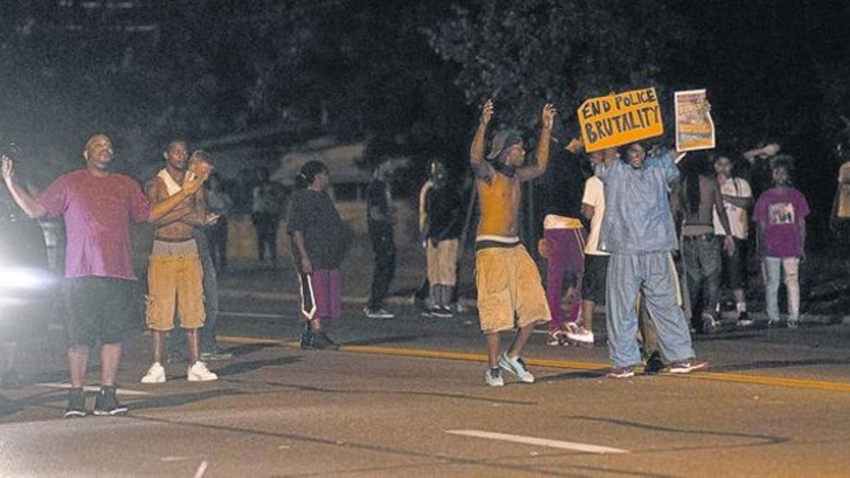 Un grupo de manifestantes protestan por el asesinato de Michael Brown en una calle de Ferguson, en el estado de Misuri, ayer.