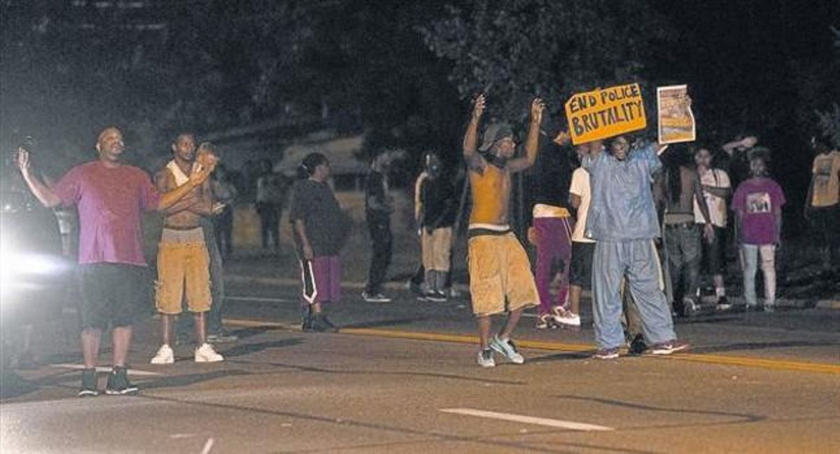 Un grup de manifestants protesten per l’assassinat de Michael Brown en un carrer de Ferguson, a l’estat de Missouri, ahir. Un grup de manifestants protesten per l’assassinat de Michael Brown en un carrer de Ferguson, a l’estat de Missouri, ahir.