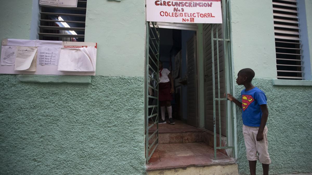 Un niño observa hacia el interior de un colegio electoral durante la votación por el referendo sobre el nuevo código de familia hoy, en La Habana (Cuba). EFE/Yander Zamora