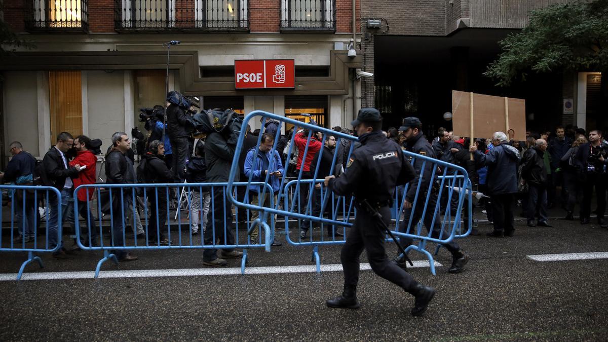 Periodistas, policías y decenas de simpatizantes, ante la sede del PSOE en MAdrid.