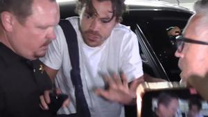 Harry Styles, pidiendo calma a sus escoltas y a sus fans en el aeropuerto de Barceona