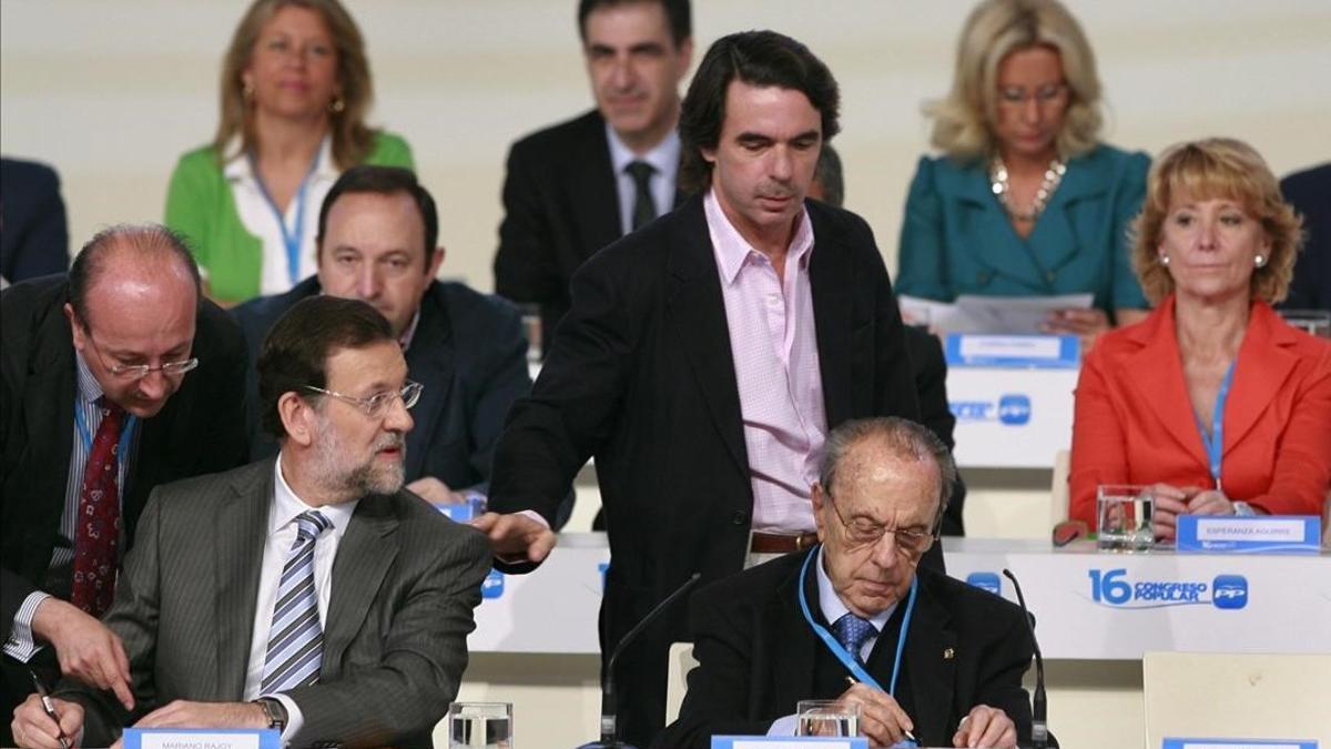 José María Aznar pasa por el lado de Mariano Rajoy, sentado junto a Manuel Fraga, en la clausura del XVI congreso nacional del PP, en el 2008 en València.