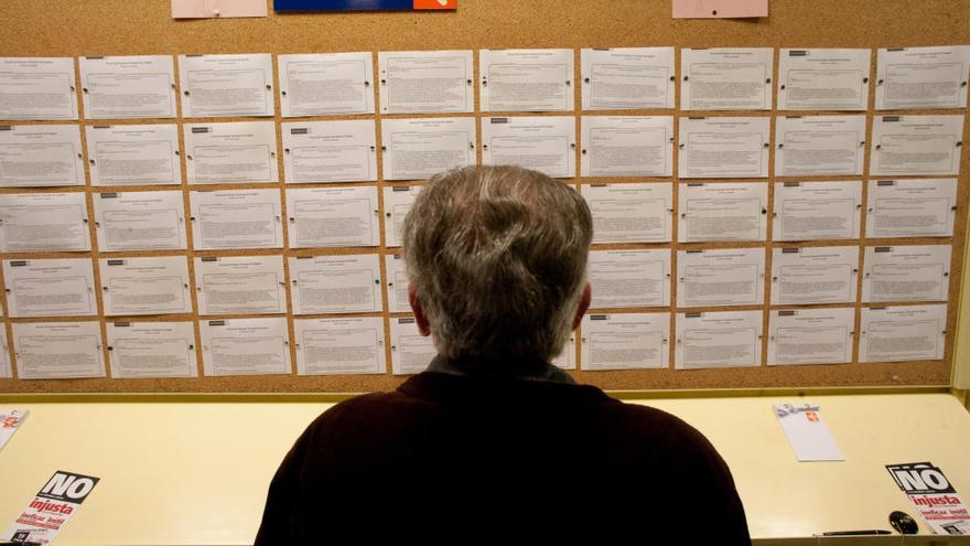 Un hombre mira ofertas laborales en una oficina de empleo de la ciudad.
